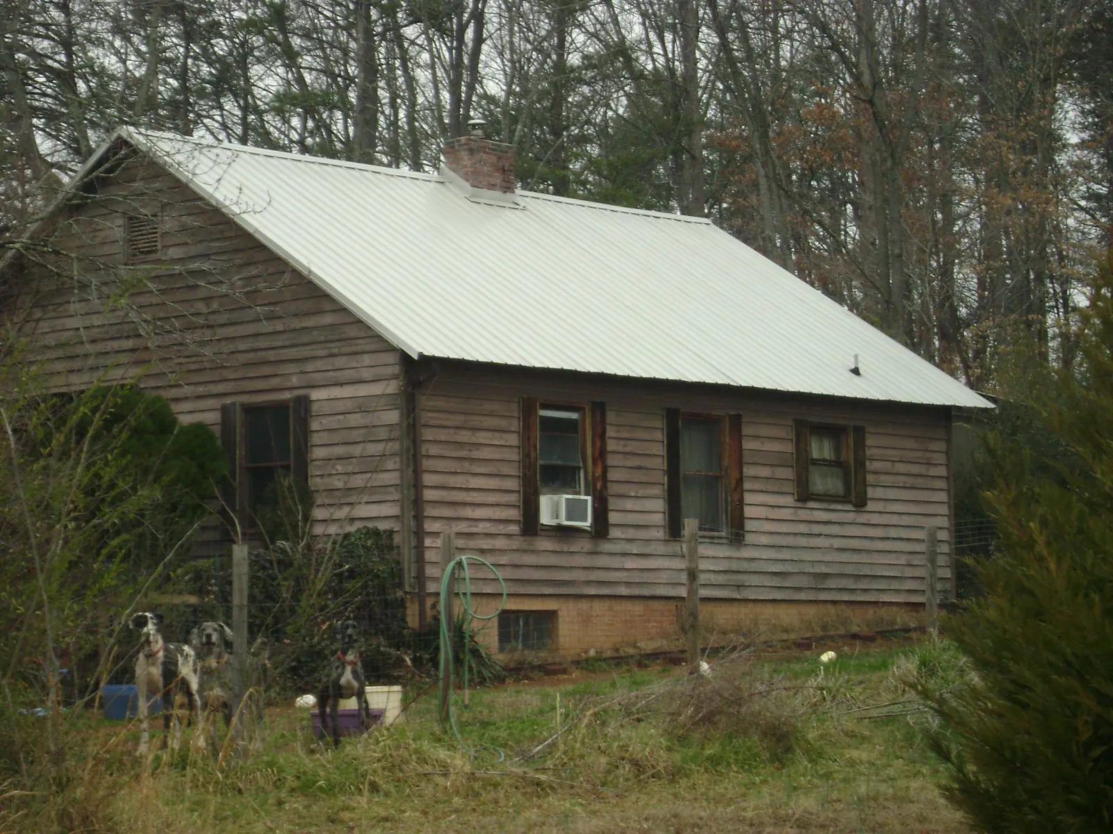 White metal roof on an old wood sided farmhouse, from a Metal Roof Installation job in Waterbury